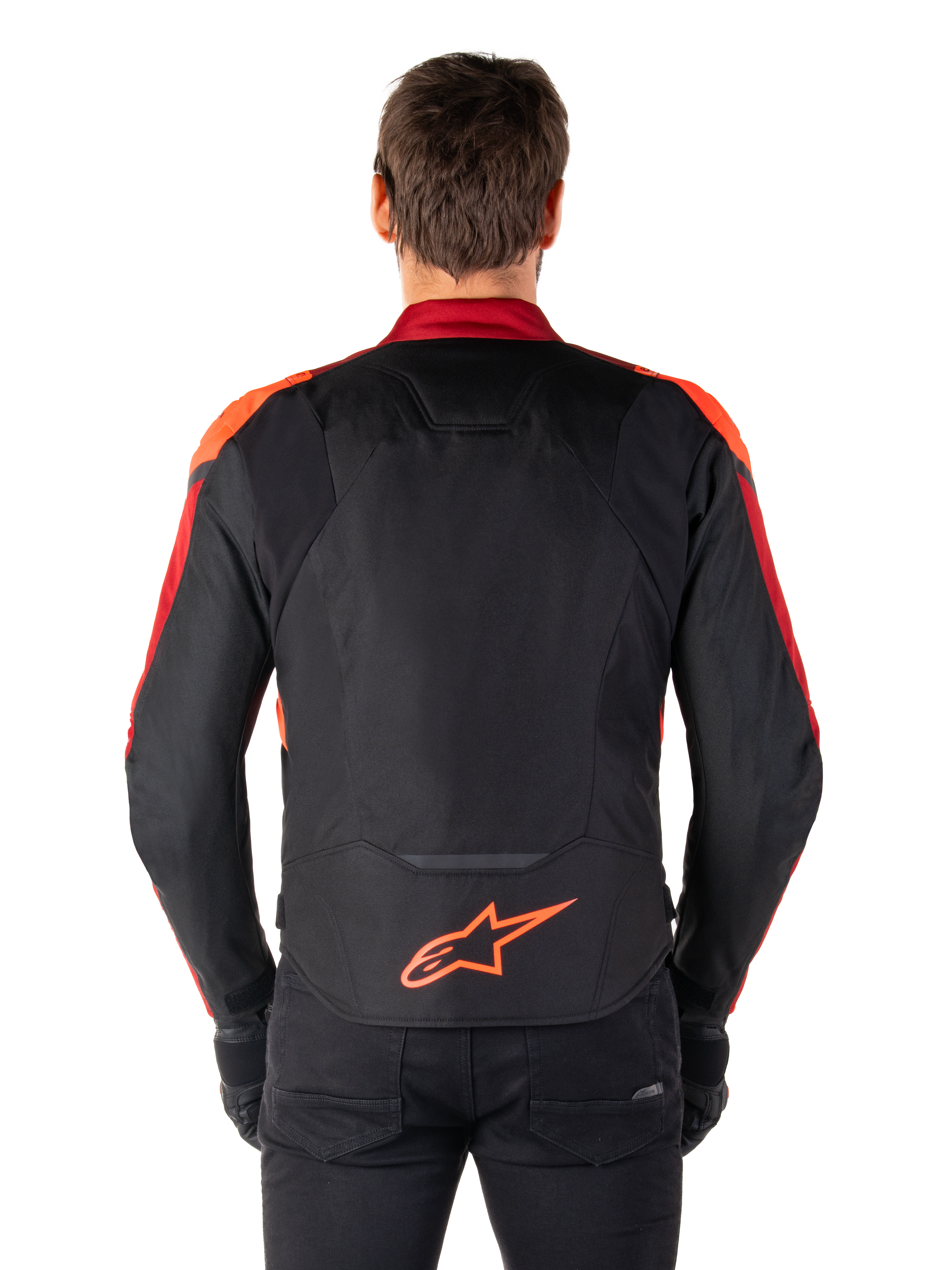 Alpinestars T-Jaws V4 Wasserdichte Jacke, Rückansicht, Schwarz mit Red Fluo und dunkelroten Akzenten, orangefarbenes Logo am unteren Rücken, verlängerte Rückenpartie für bessere Abdeckung beim Fahren, sportliche Textil-Motorradjacke