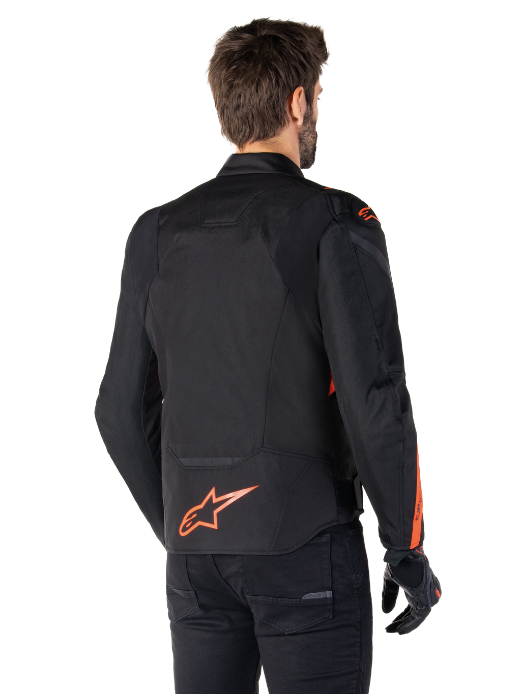 Männliches Modell in der Alpinestars T-Jaws V4 Wasserdichten Jacke in der Rückansicht, Schwarz mit Red Fluo Akzenten, mit einem Red Fluo Logo am unteren Rücken und Akzenten an den Schultern und Ärmeln, sportliche Motorradbekleidung.