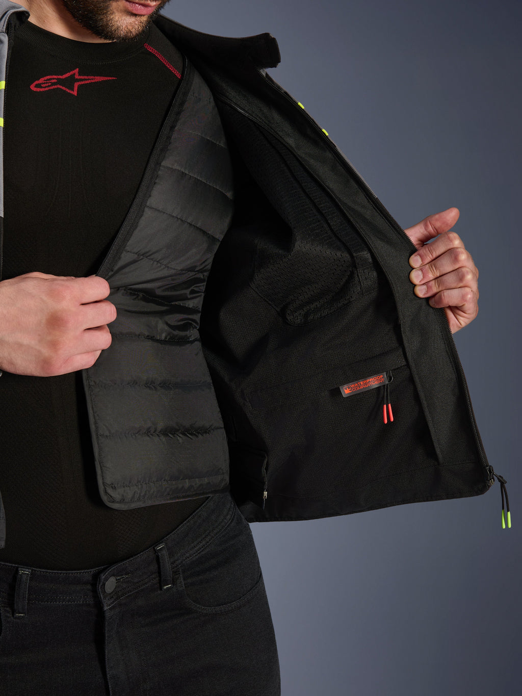 Alpinestars T-Jaws V4 Waterproof Jacket interior view, showcasing the removable black quilted thermal liner and a red-labeled waterproof inner compartment, featuring mesh lining and premium motorcycle protective gear construction.