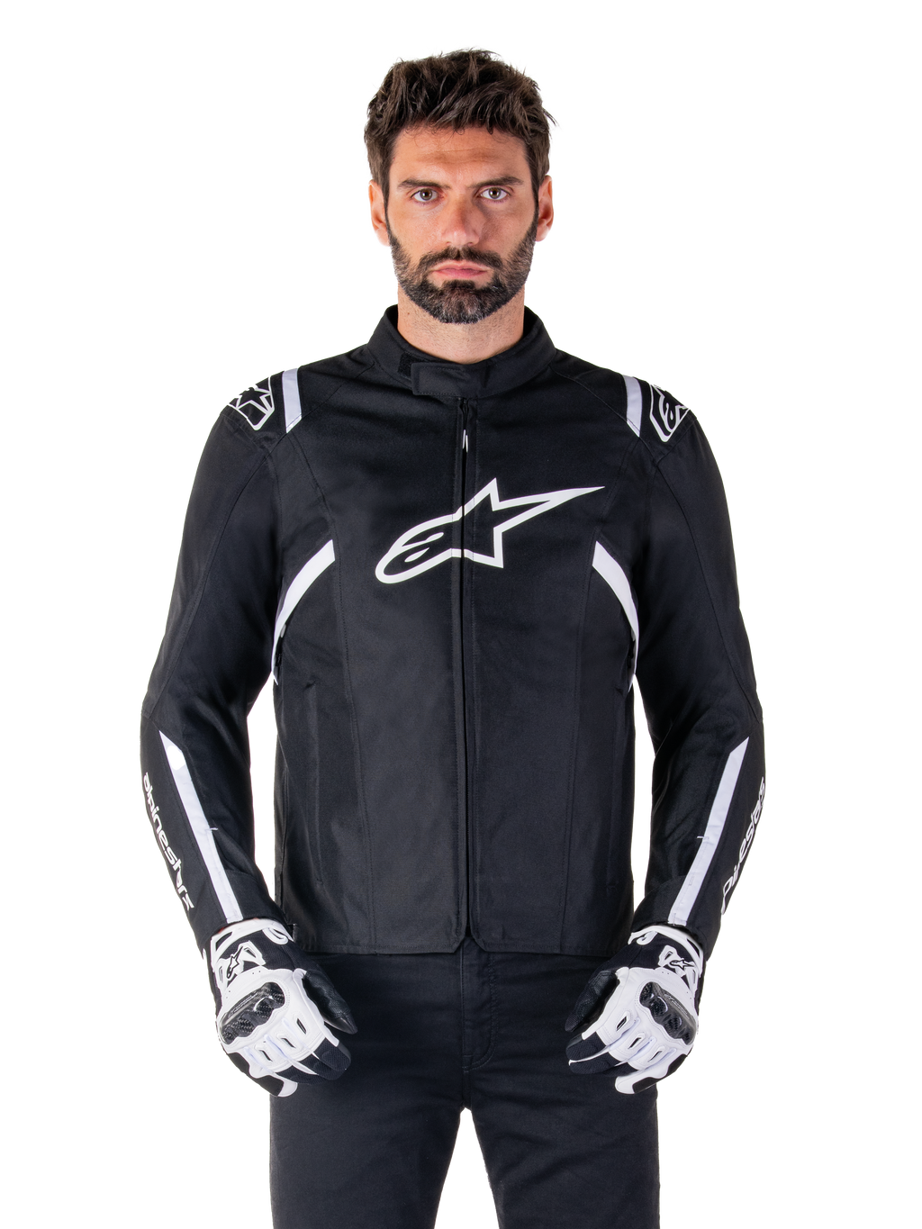 Alpinestars T-SPS V2 Waterproof Jacket in Black and White, front view on model, waterproof textile motorcycle jacket featuring white shoulder and arm stripes, large white Alpinestars logo on chest, worn with protective motorcycle gloves, sleek sport-inspired silhouette