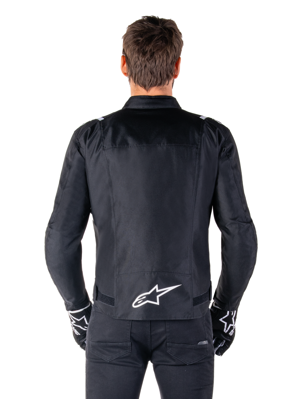 Alpinestars T-SPS V2 Waterproof Jacket, Black and White, back view showing white Alpinestars logo on lower back, worn with black pants and gloves, sport cut textile motorcycle jacket