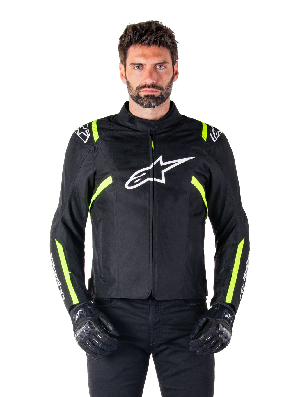 Veste imperméable Alpinestars T-SPS V2, veste de moto, noire avec des accents blancs et jaune fluo, portée par un mannequin avec des gants noirs, dotée d'un logo étoile blanc sur la poitrine et de bandes jaune fluo sur les manches et les épaules, équipement textile de style sport pour rouler par tous les temps