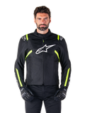 Veste imperméable Alpinestars T-SPS V2, veste de moto, noire avec des accents blancs et jaune fluo, portée par un mannequin avec des gants noirs, dotée d'un logo étoile blanc sur la poitrine et de bandes jaune fluo sur les manches et les épaules, équipement textile de style sport pour rouler par tous les temps