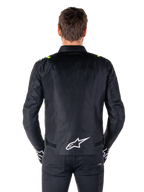 Veste imperméable Alpinestars T-SPS V2, vue de dos, noire avec des accents jaune fluo sur les épaules et logo étoile blanc dans le bas du dos, veste de moto en textile à la silhouette sport, portée par un mannequin homme
