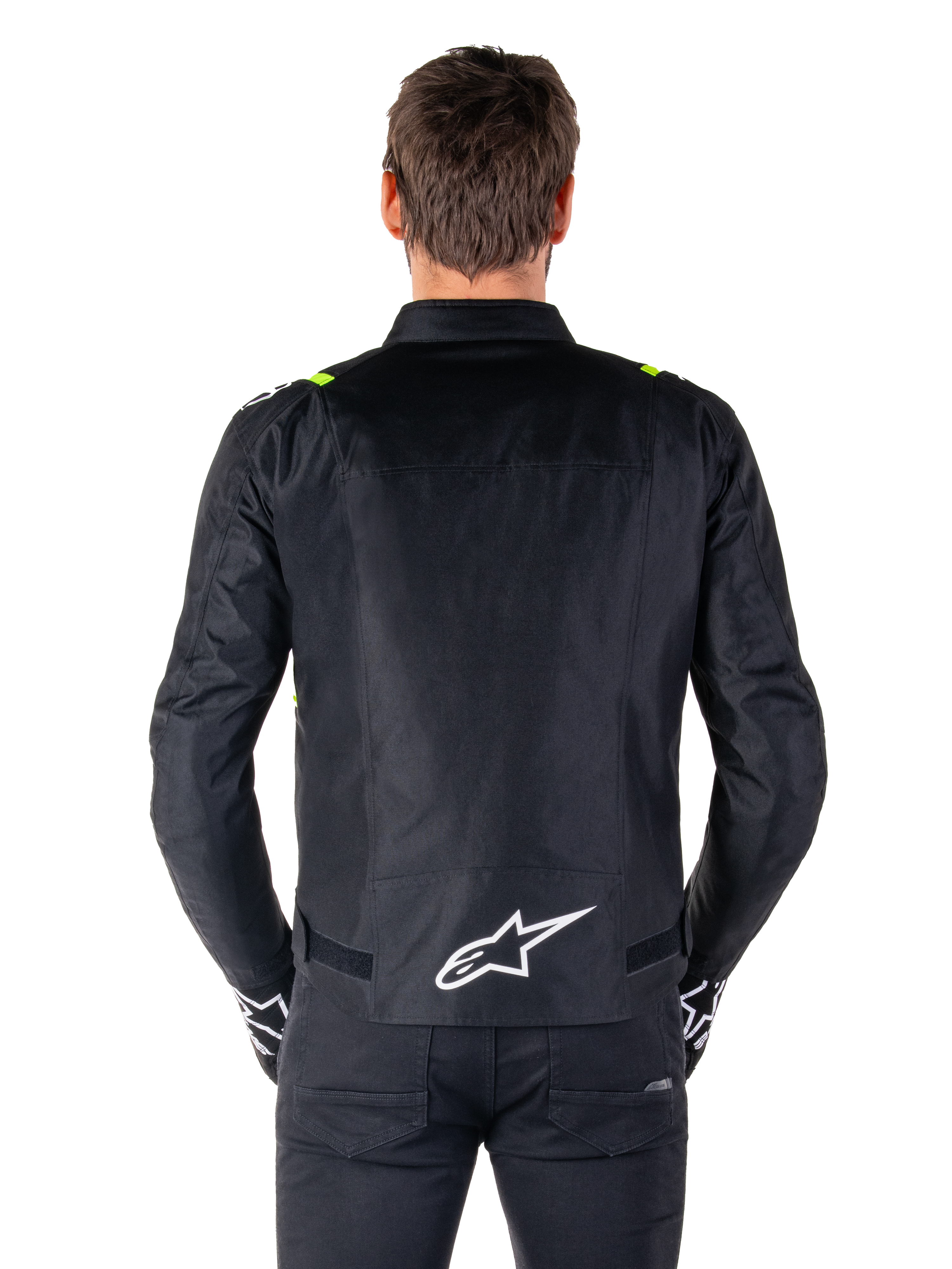 Veste imperméable Alpinestars T-SPS V2, vue de dos, noire avec des accents jaune fluo sur les épaules et logo étoile blanc dans le bas du dos, veste de moto en textile à la silhouette sport, portée par un mannequin homme