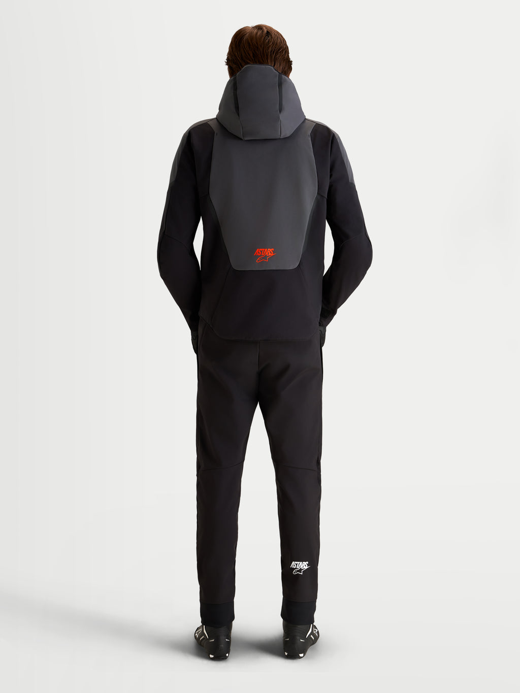 Alpinestars Aeroshell Waterproof Jacket, heren motorjas in zwart en donkergrijs, achteraanzicht met geïntegreerde capuchon en rood Alpinestars-logo, CE-gecertificeerde textieluitrusting