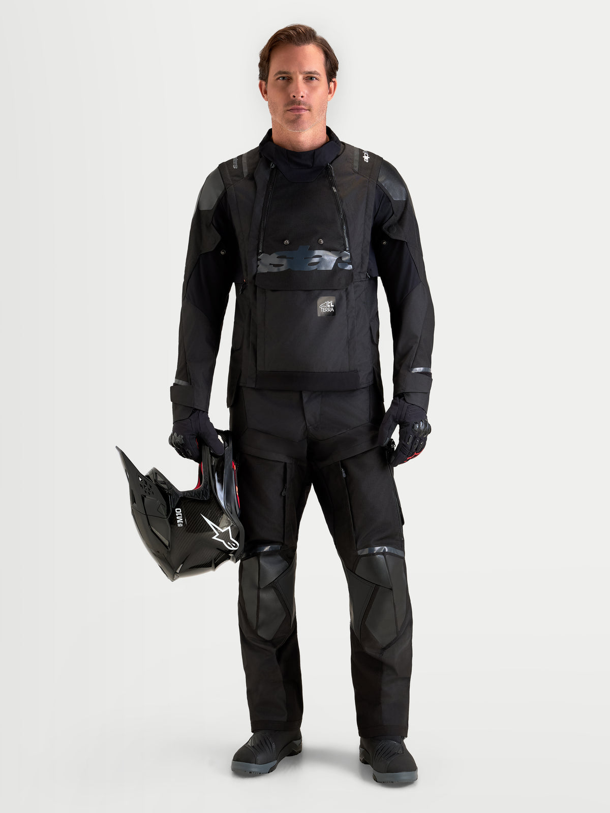 Alpinestars Harok V2 Drystar jas, heren adventure motorjas in het zwart dragend bij bijpassende rijbroek en helm, waterdichte textielconstructie met modulaire ventilatie