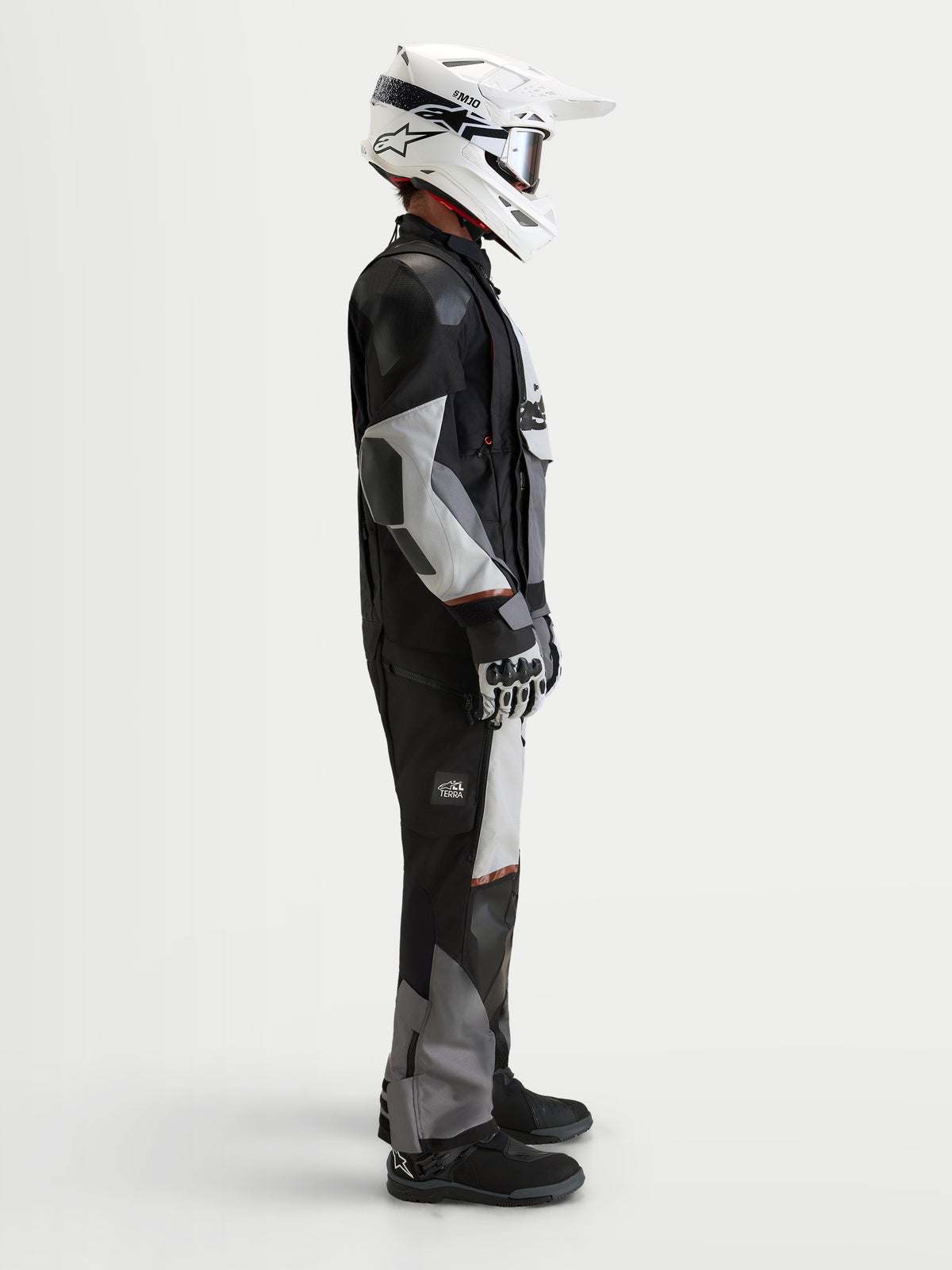 Alpinestars Harok V 2 Drystar jas, heren-adventure-motorjas, donkergrijs, ijsgrijs en zwart, gedragen met witte helm en adventure-uitrusting in zijaanzicht