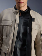 Veste Alpinestars Borrego Drystar® en Warm Gray, vue rapprochée montrant le devant ouvert, doublure interne noire et texte technique incluant « ALPINESTARS PROTECTS » et la compatibilité avec une protection de poitrine, style moto aventure robuste