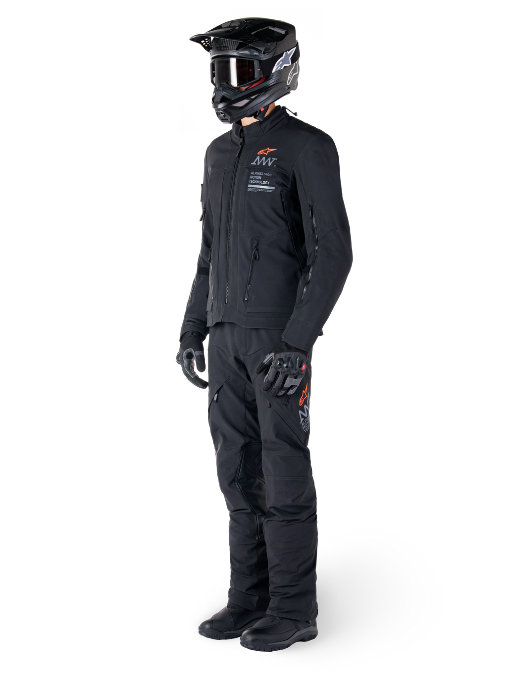 Alpinestars AMT-8 Stretch Drystar® XF Jacke, Adventure-Motorradjacke, Schwarz, getragen mit passender Hose, Helm und Handschuhen, mit Alpinestars Motion Technology Branding und orangefarbenen Akzenten, strapazierfähige Stretch-Konstruktion für Adventure-Touren