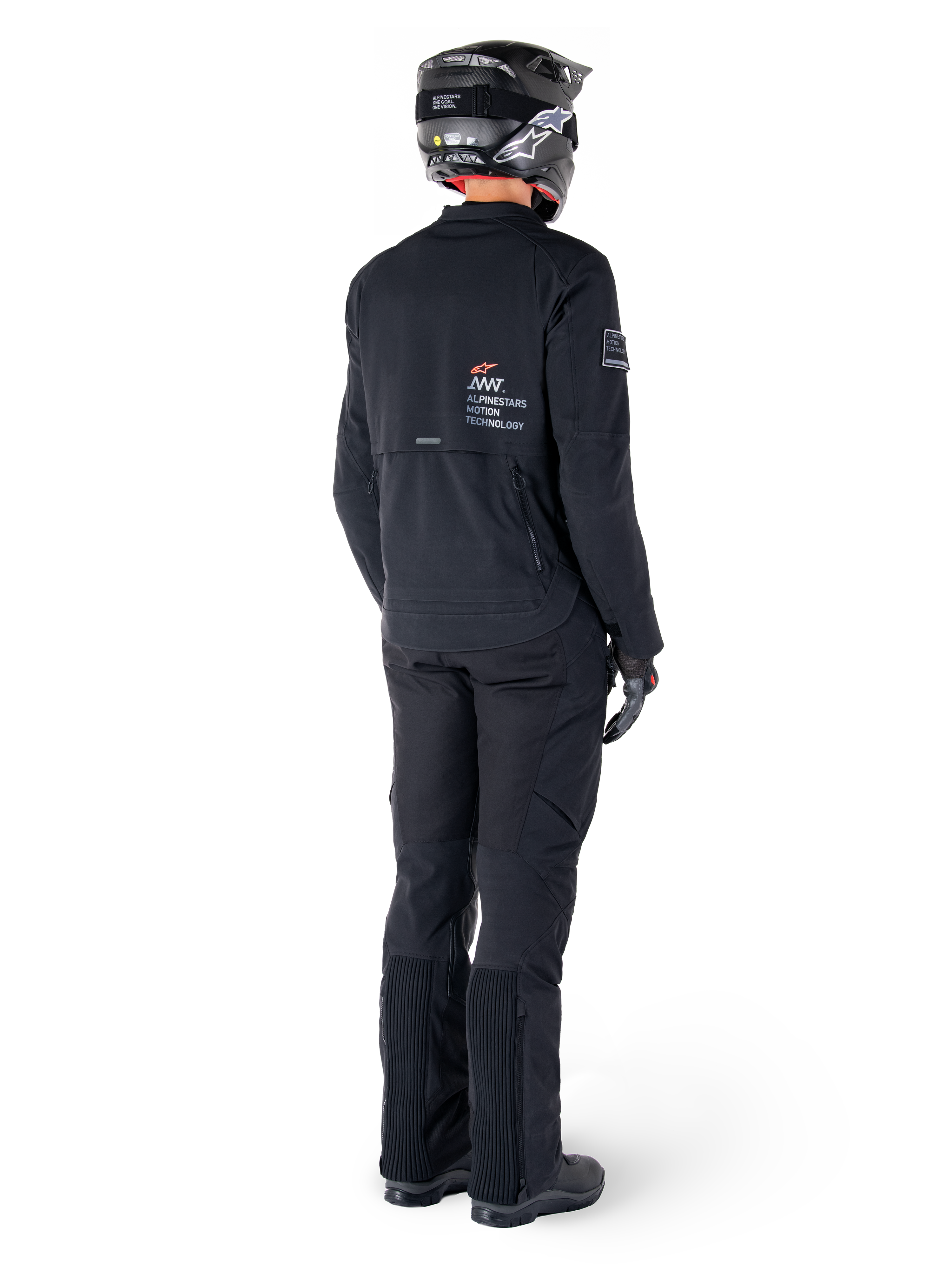 Alpinestars AMT-8 Stretch Drystar® XF Jacke, Schwarz, Rückansicht eines Fahrers mit passender schwarzer Hose und schwarzem Helm, mit „Alpinestars Motion Technology“-Branding auf dem Rücken, technisches Stretchmaterial für Adventure-Motorradtouren