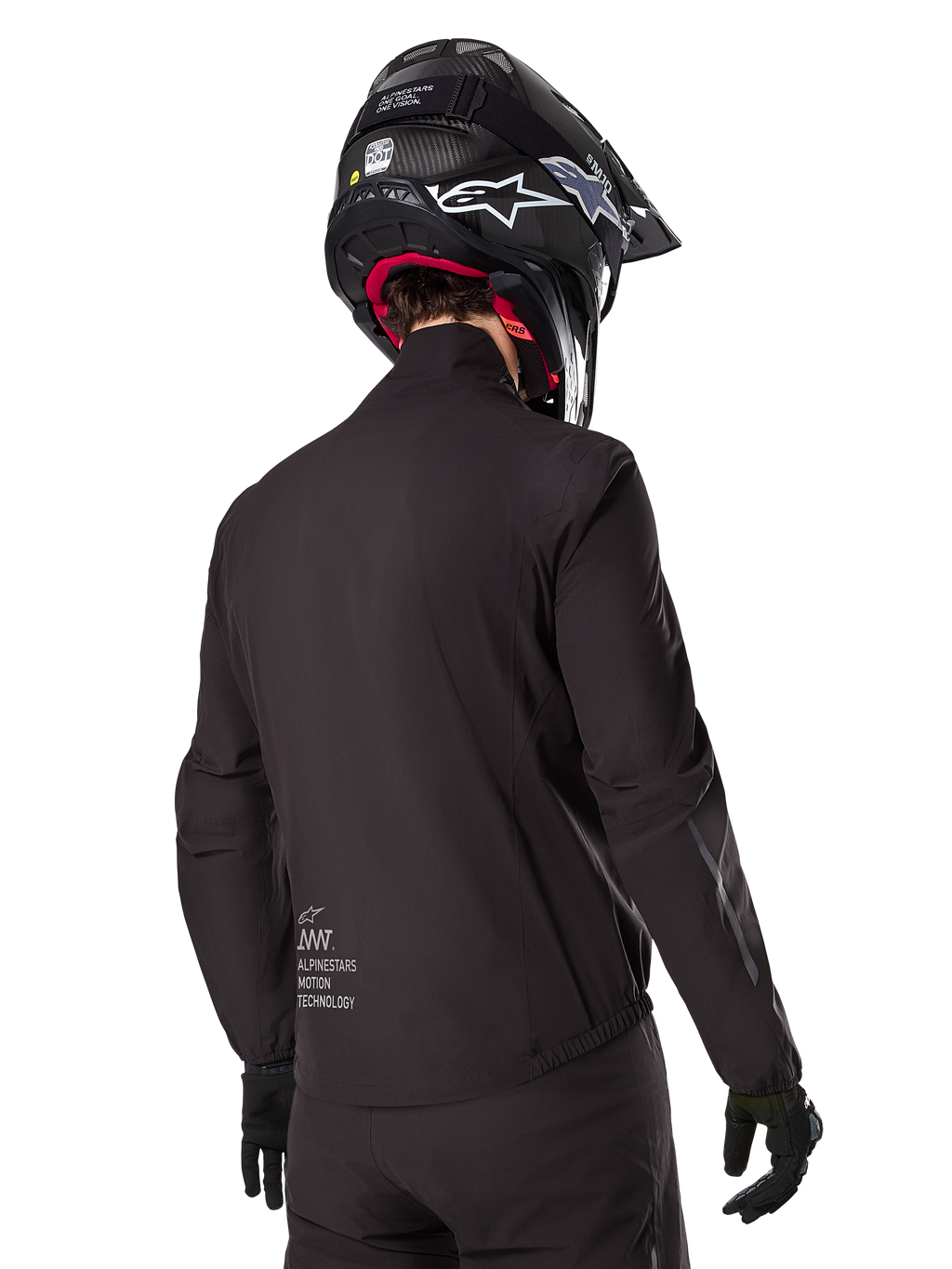 Alpinestars AMT-8 Stretch Drystar® XF Liner, schwarze wasserdichte Innenjacke, Rückansicht eines Fahrers mit schwarzem Helm und Handschuhen, mit Alpinestars Motion Technology-Branding am unteren Rücken, minimalistisches und funktionales Design für Adventure-Fahrten.