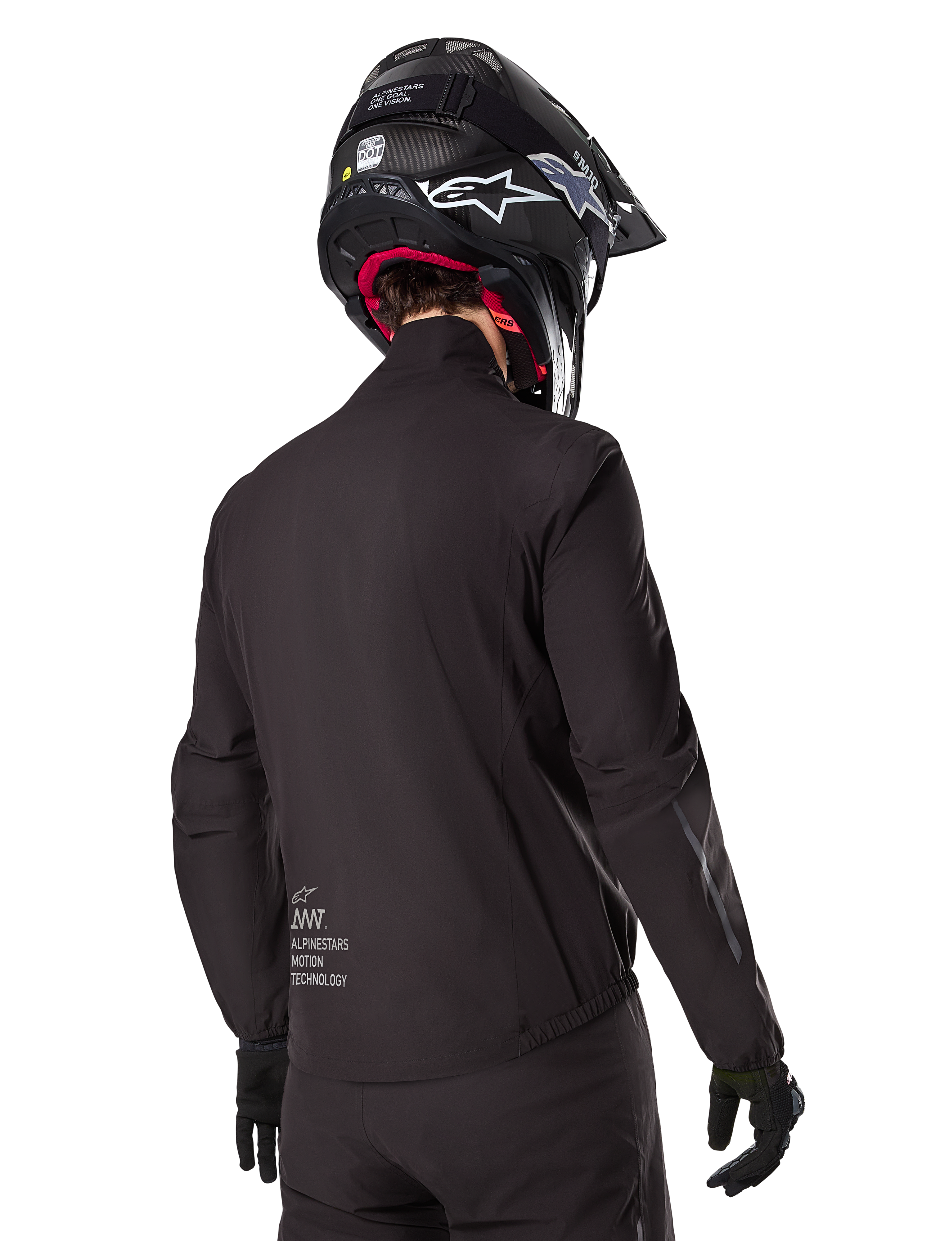 Alpinestars AMT-8 Stretch Drystar® XF Liner, schwarze wasserdichte Innenjacke, Rückansicht eines Fahrers mit schwarzem Helm und Handschuhen, mit Alpinestars Motion Technology-Branding am unteren Rücken, minimalistisches und funktionales Design für Adventure-Fahrten.