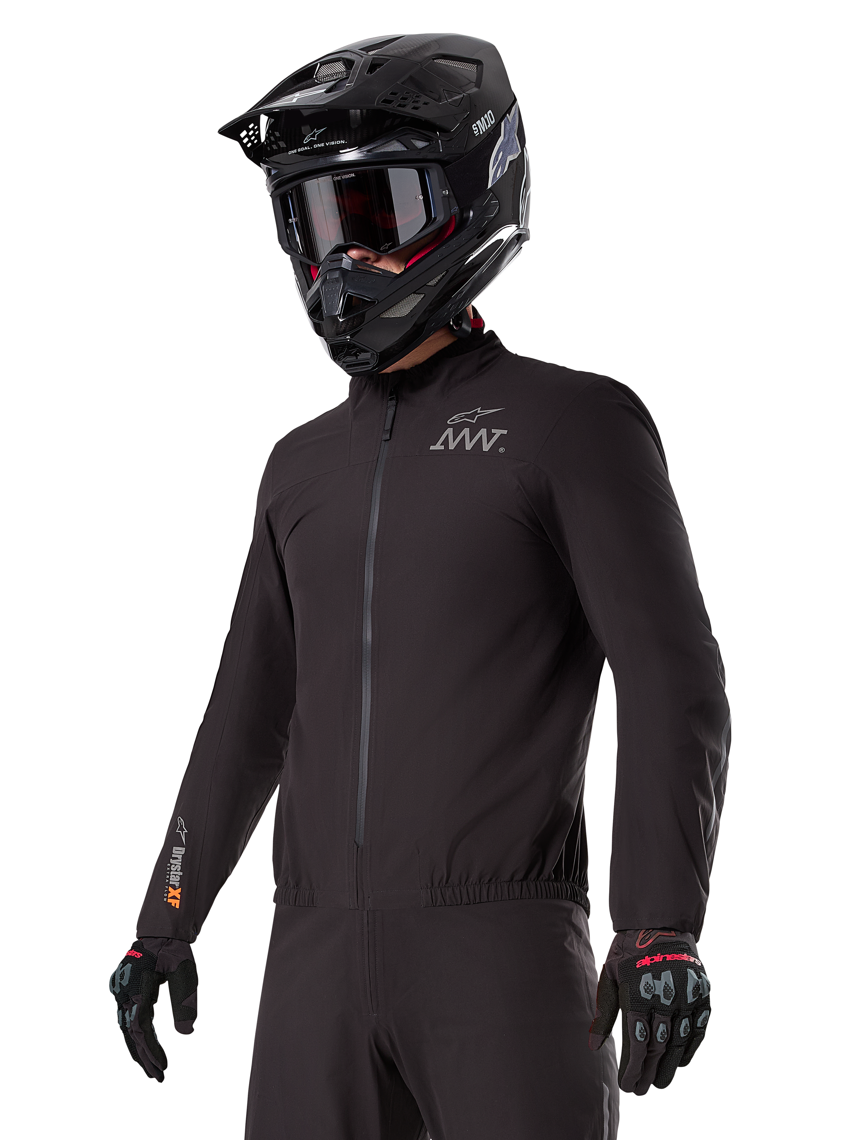 Fahrer trägt den Alpinestars AMT-8 Stretch Drystar® XF Liner, schwarze wind- und wasserdichte Stretchjacke, mit AMT-Logo auf der Brust und Drystar-XF-Branding auf dem Ärmel, kombiniert mit einem schwarzen Adventure-Helm und Schutzhandschuhen.