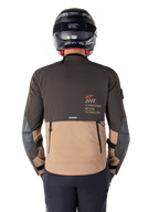 Veste Alpinestars AMT-8 Stretch Drystar® XF, vue arrière, design bicolore marron foncé et kaki foncé, avec marquage Alpinestars Motion Technology, poche cargo arrière zippée et panneaux de protection aux coudes, équipement de moto aventure touring