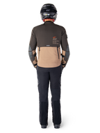 Veste Alpinestars AMT-8 Stretch Drystar® XF, veste Adventure Touring, brun foncé et kaki foncé, vue arrière montrant le marquage Alpinestars Motion Technology dans le dos, portée avec un pantalon noir et un casque intégral noir, textile extensible haute performance pour équipement de moto d'aventure