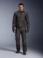 Männliches Model in der Alpinestars Andes V4 Drystar® Jacke in Schwarz, kombiniert mit passender Adventure-Motorradhose, schwarzen Handschuhen und schwarzen Stiefeln, Ganzkörper-Studioaufnahme technischer Allwetter-Tourenbekleidung mit Alpinestars-Branding.