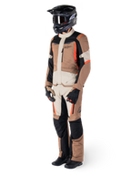 Alpinestars ST-1 Wasserdichte Jacke, Dark Khaki Sand Black Red Fluo, getragen von einem Fahrer in kompletter Adventure-Touring-Ausrüstung mit passender Hose, schwarzem Helm, Schutzbrille, Handschuhen und Stiefeln, technische Allwetter-Motorradausrüstung.