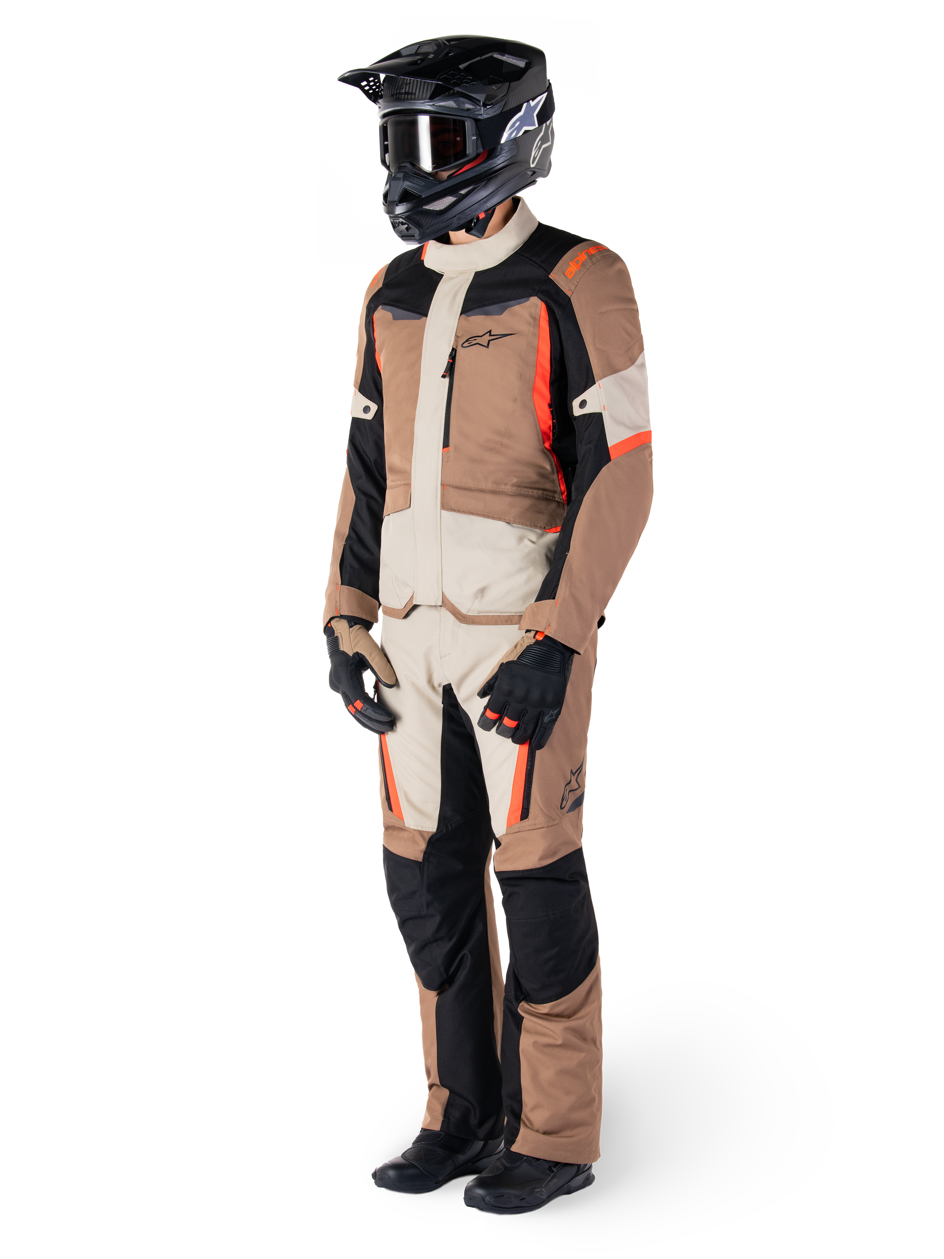 Alpinestars ST-1 Wasserdichte Jacke, Dark Khaki Sand Black Red Fluo, getragen von einem Fahrer in kompletter Adventure-Touring-Ausrüstung mit passender Hose, schwarzem Helm, Schutzbrille, Handschuhen und Stiefeln, technische Allwetter-Motorradausrüstung.