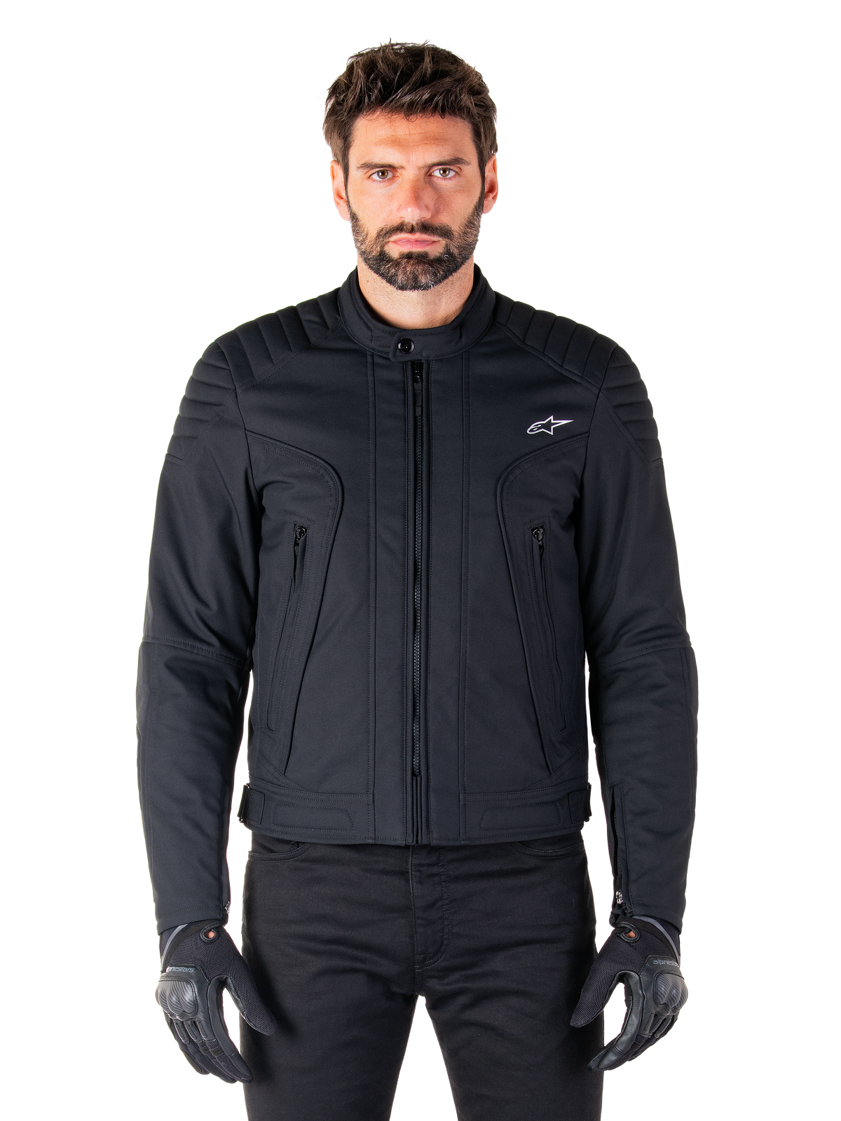 Veste Alpinestars Clayton WR, veste de moto noire portée par un mannequin, avec détails matelassés aux épaules et graphismes techniques, fermeture éclair centrale Vislon, poches zippées verticales, petit logo blanc sur la poitrine, équipement de conduite urbaine pour la route