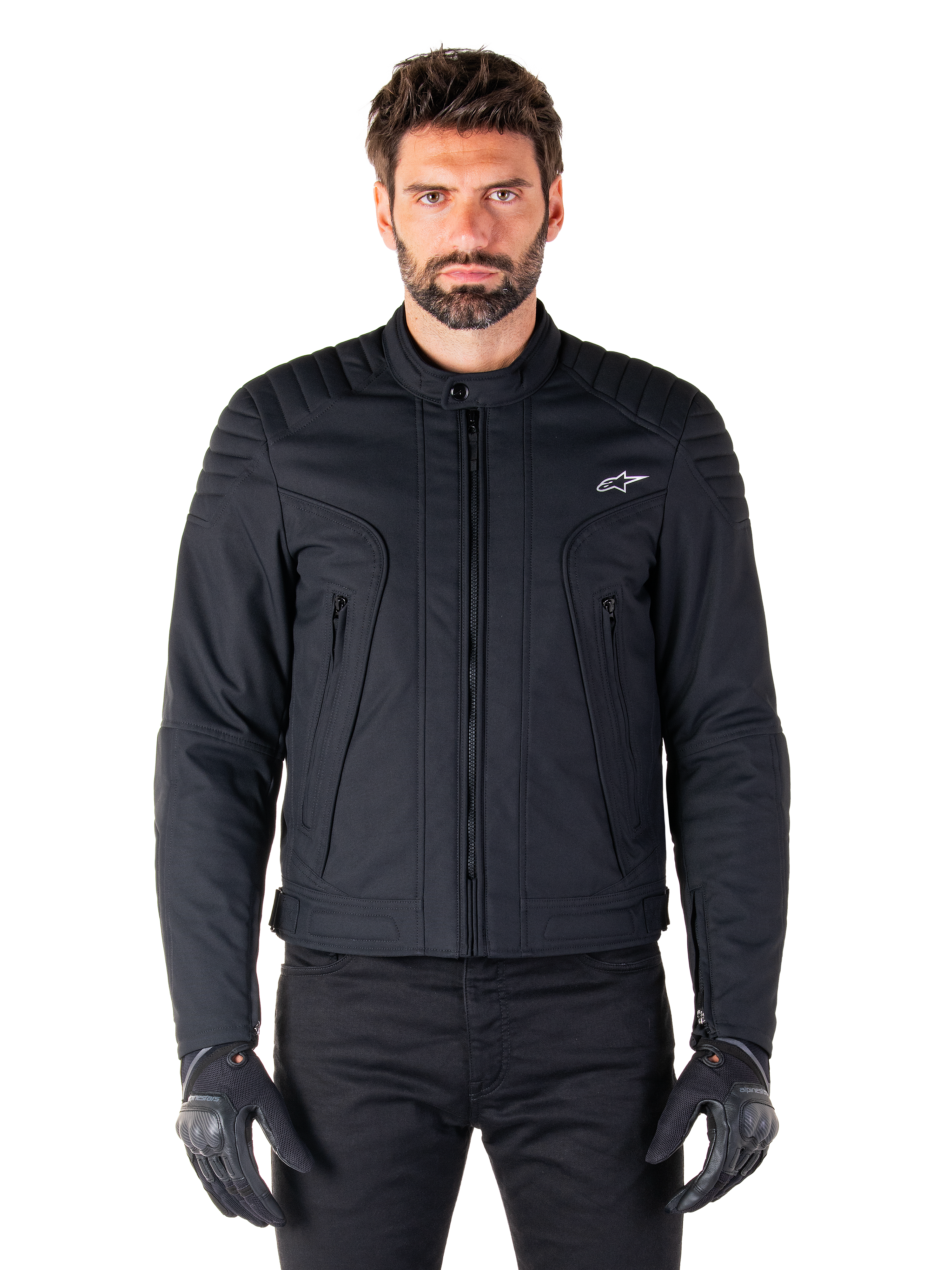 Alpinestars Clayton WR Jacket, zwarte motorjas, gedragen door een model, voorzien van gewatteerde schouderdetails en technische graphics, centrale Vislon-rits, verticale zakken met rits, klein wit logo op de borst, stedelijke motorkleding voor weggebruik