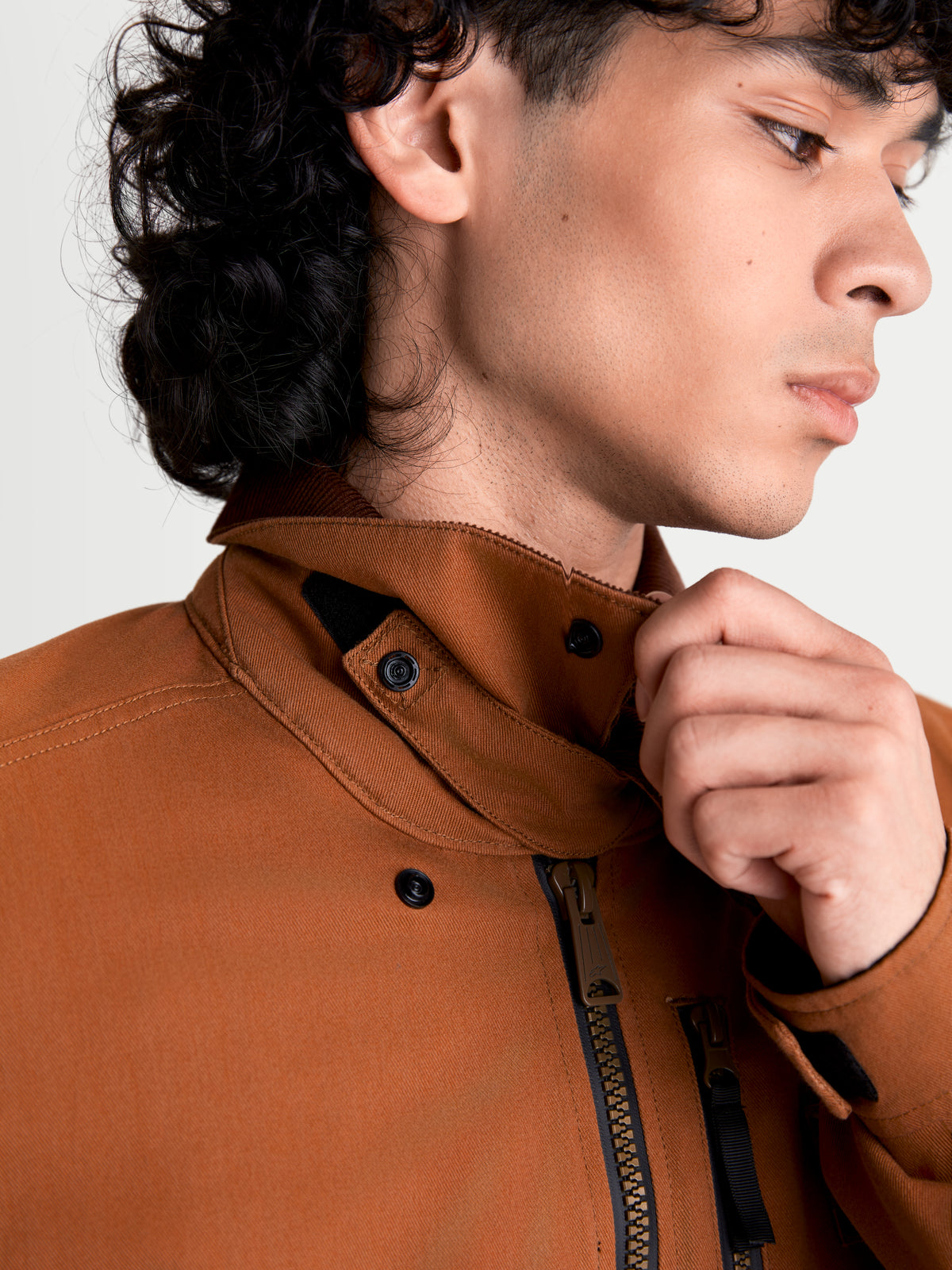 Alpinestars Mustang Waterproof Jacket, men's urban contemporary motorcycle jacket in dark rust and dark brown, close-up view showing the stretch twill collar and front zipper construction worn by a model.