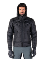 Alpinestars Mohobbs Waterproof Jacket, zwart gewatteerd motorbomberjack, ontwerp met capuchon en wit sterlogo op de borst, ritssluiting aan de voorzijde, urban streetwear-stijl voor motorrijders