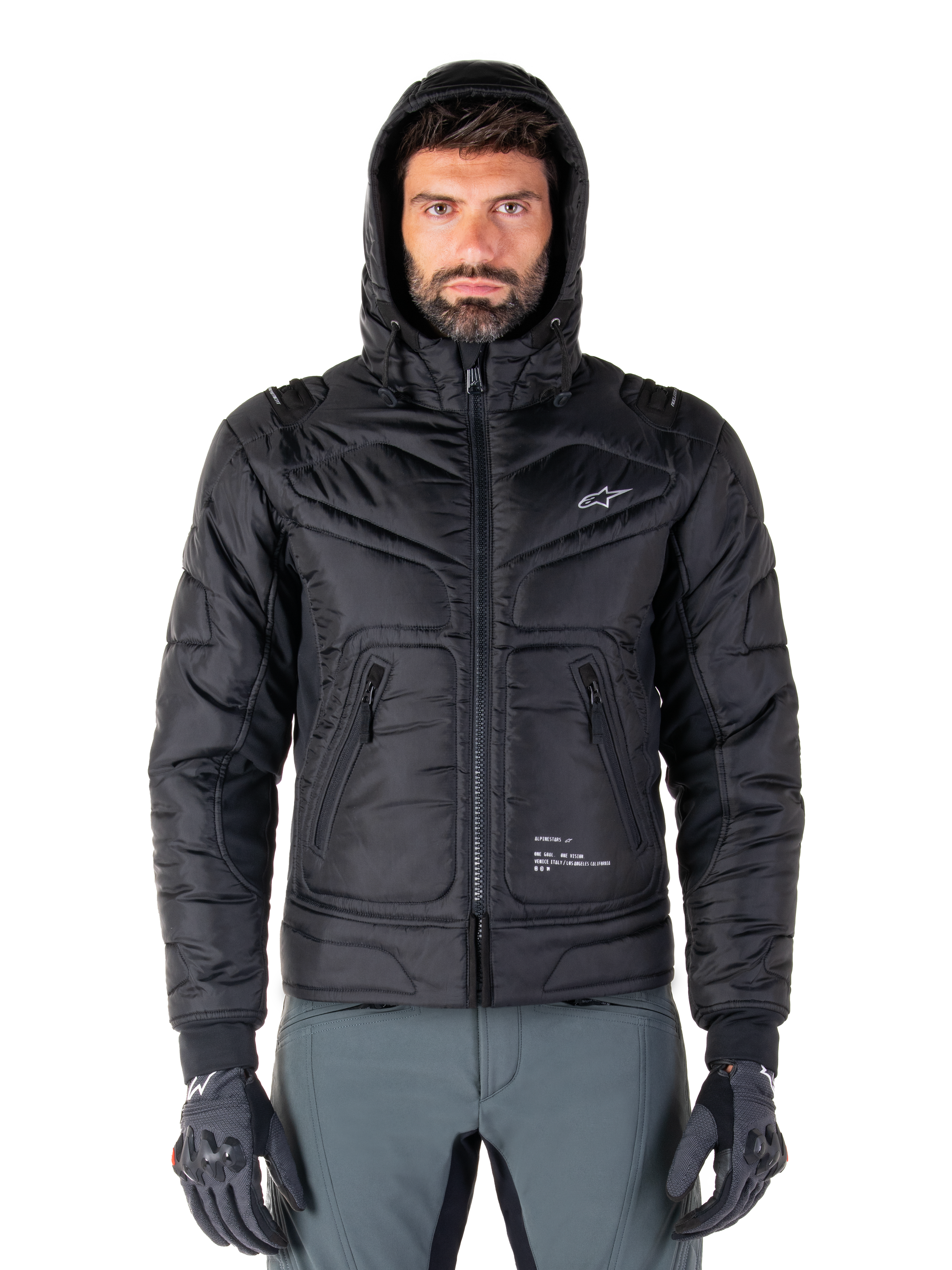 Alpinestars Mohobbs Waterproof Jacket, zwart gewatteerd motorbomberjack, ontwerp met capuchon en wit sterlogo op de borst, ritssluiting aan de voorzijde, urban streetwear-stijl voor motorrijders