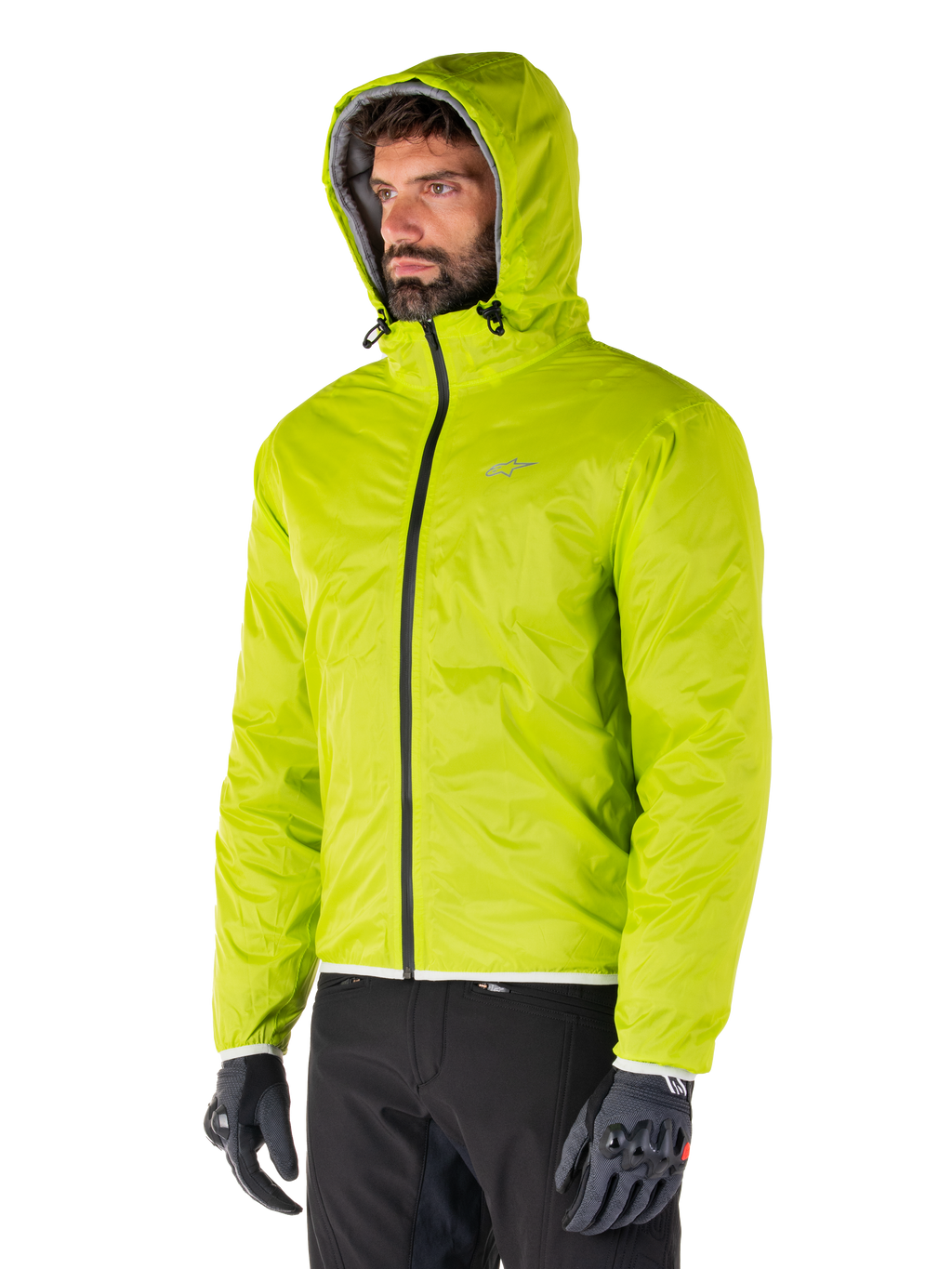 Alpinestars Mohobbs Wasserdichte Jacke, verstaubares Regenfutter in Lime Punch, leuchtend neongrüne Kapuzenjacke, kombiniert mit schwarzer Hose und grauen Handschuhen, von Urban Streetwear inspirierte Motorradbekleidung