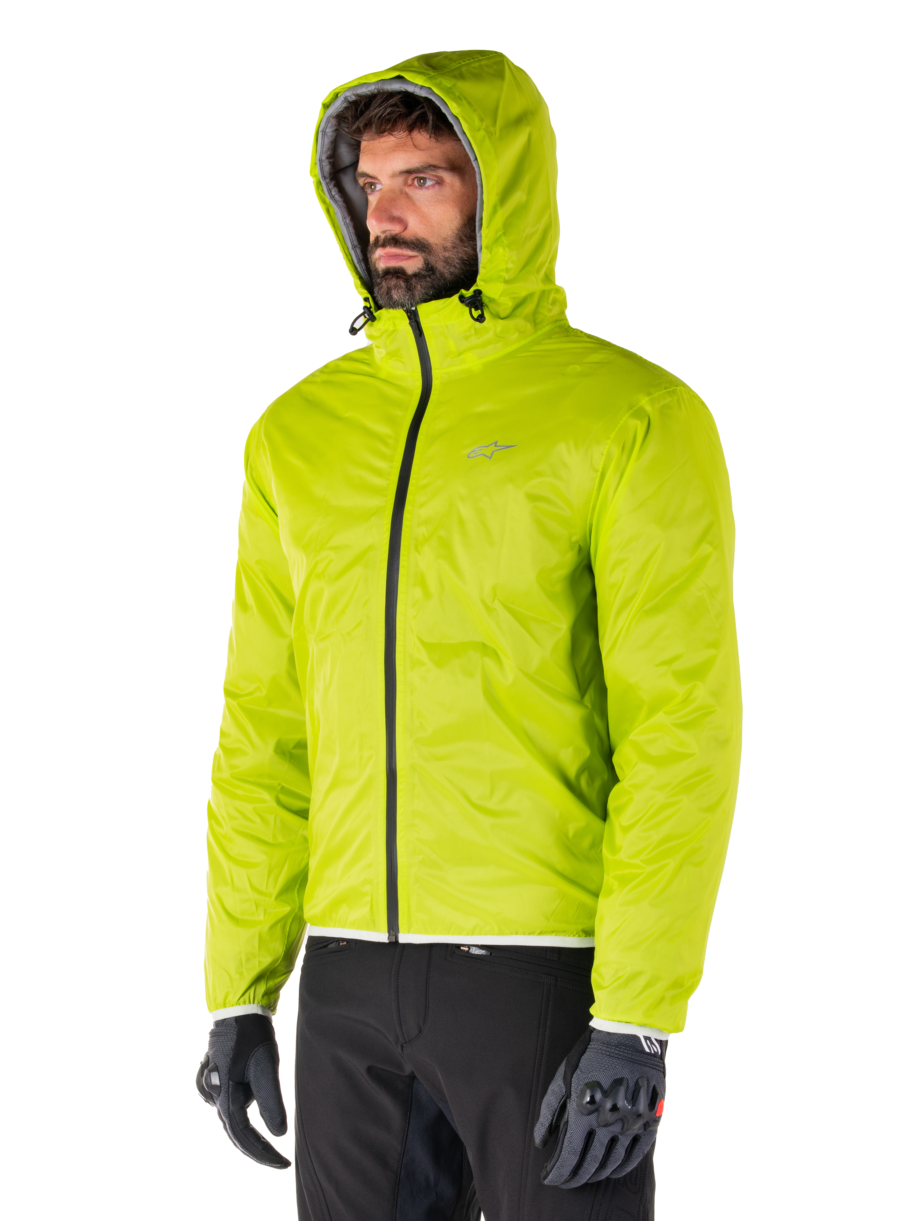 Alpinestars Mohobbs Wasserdichte Jacke, verstaubares Regenfutter in Lime Punch, leuchtend neongrüne Kapuzenjacke, kombiniert mit schwarzer Hose und grauen Handschuhen, von Urban Streetwear inspirierte Motorradbekleidung