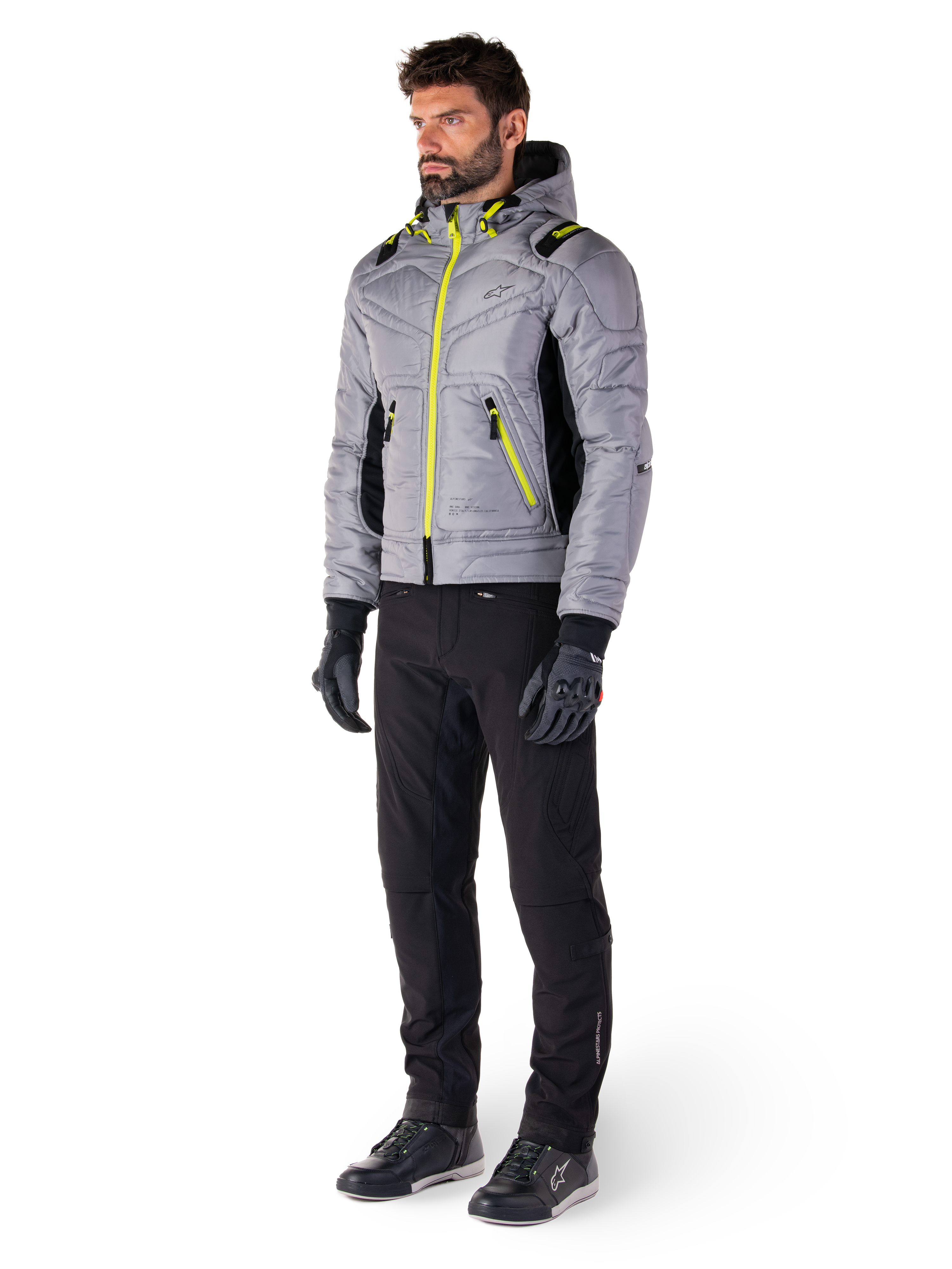 Alpinestars Mohobbs Wasserdichte Jacke in Lunar Gray und Lime Punch, gesteppte Motorradjacke im Bomber-Stil mit neonfarbenen Akzenten, getragen von einem Model mit schwarzer Fahrhose und Handschuhen, urbane Streetwear-inspirierte Schutzausrüstung