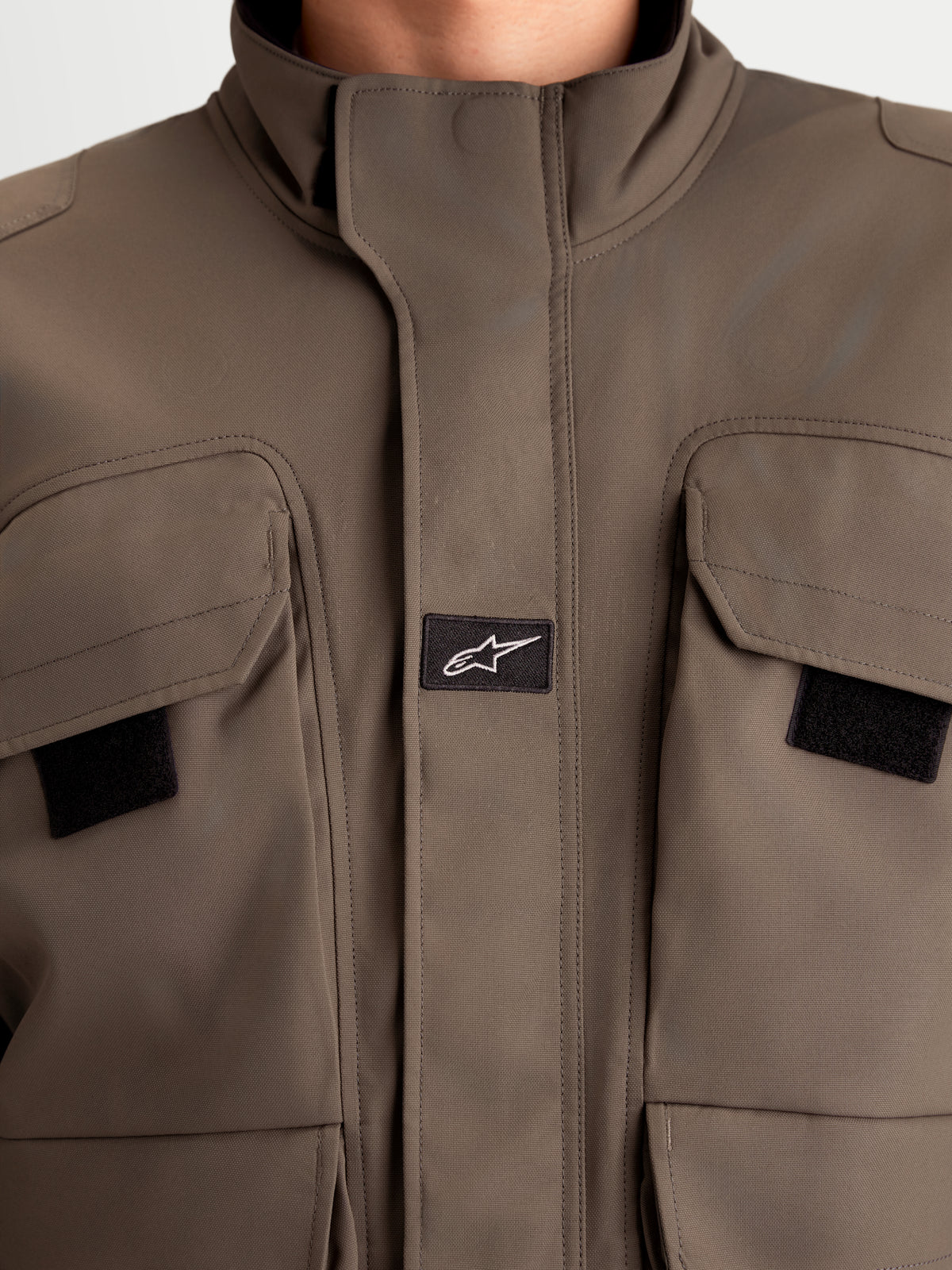 Alpinestars Altan Drystar Jacket, men's urban contemporary motorcycle jacket in walnut brown, close-up view showing matte polyfabric construction, dual-entry cargo pockets, and integrated warm collar