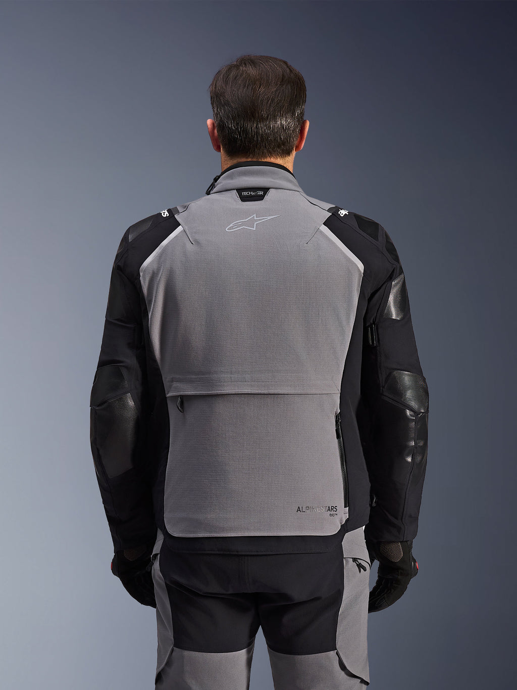 Alpinestars Andes Pro Drystar® XF Jacke, Rückansicht, Dunkelgrau und Schwarz, Adventure-Tourenjacke mit großer Rückentasche, Tech-Air® Ready-Branding am Kragen und verstärkten Ellbogenpaneelen.