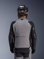 Alpinestars Andes Pro Drystar® XF Jacke, Dunkelgrau und Schwarz, Rückansicht mit großer Rückentasche und Tech-Air®-Branding, getragen von einem Fahrer mit schwarzem Helm und passender Hose, professionelle Adventure-Touring-Ausrüstung