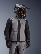 Alpinestars Andes Pro Drystar® XF Jacke, Dunkelgrau und Schwarz, Adventure-Motorradjacke getragen mit schwarzem SM10 Helm und passender Fahrausrüstung, 3-lagiges Textildesign mit zentralem Reißverschluss und Brusttaschen, ergonomisches Design für Allwetter-Touren