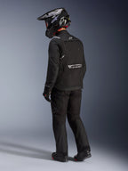 Alpinestars Cusco Drystar® Jacket in Black, rear-side view of a rider wearing a full adventure touring kit including matching black pants and gloves, black adventure helmet, textile construction with reflective branding on the back