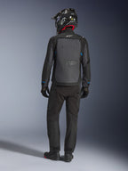 Veste Alpinestars Cusco Drystar®, noir et gris foncé, vue arrière d'un motard en tenue complète d'aventure touring, grand panneau arrière gris avec logo Alpinestars, accents bleus sur les manches, portée avec un pantalon noir et un casque assortis.