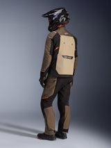 Alpinestars Cusco Drystar® Jacket, Adventure Touring Jacket, Walnut Aluminum Black, back view showing tan rear panel and orange accents, worn with matching pants and black carbon fiber helmet.