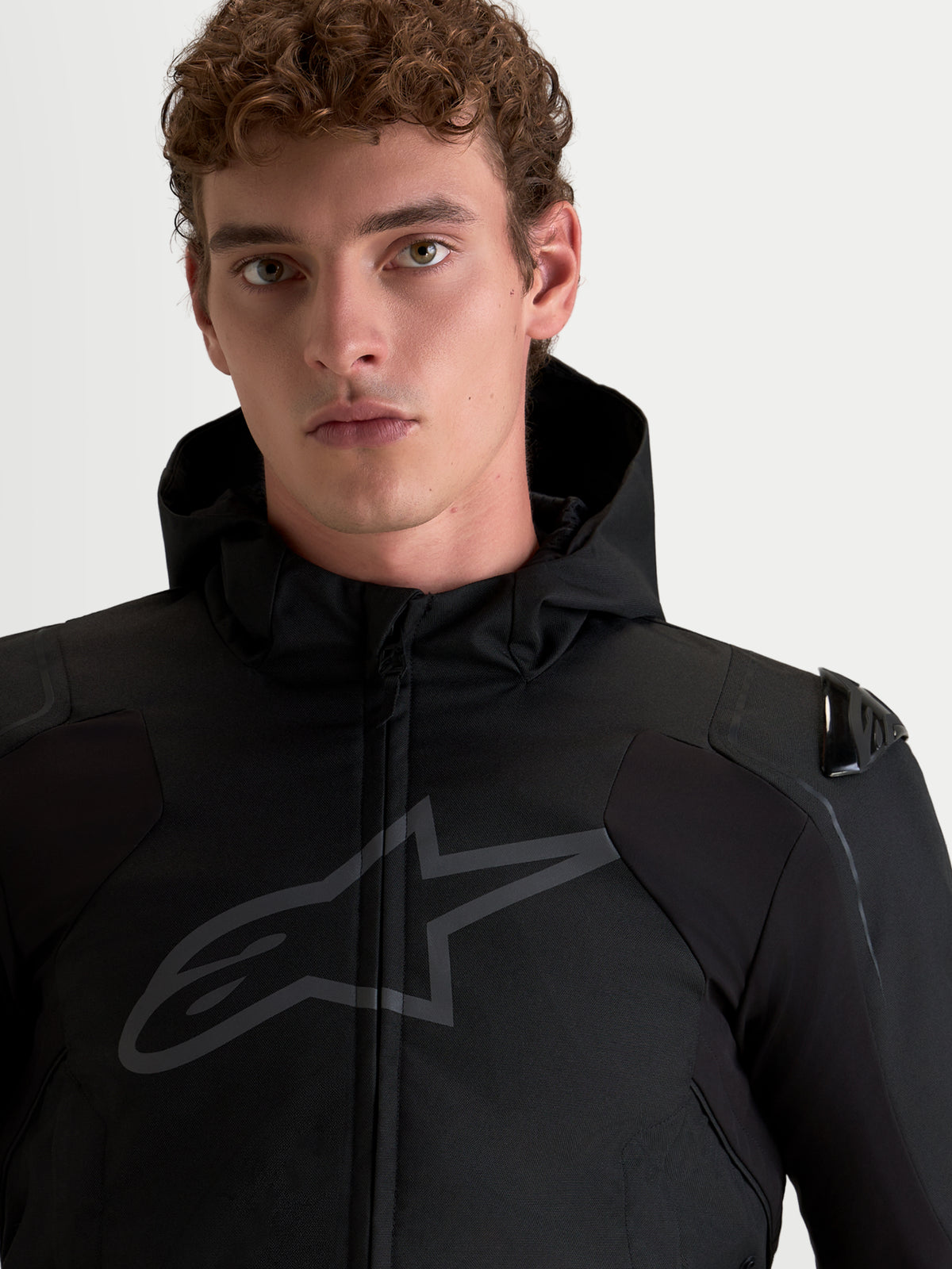 Alpinestars Zaca V 2 Waterproof, veste de moto noire pour homme avec protections d'épaules DFS et capuche intégrée, portrait rapproché