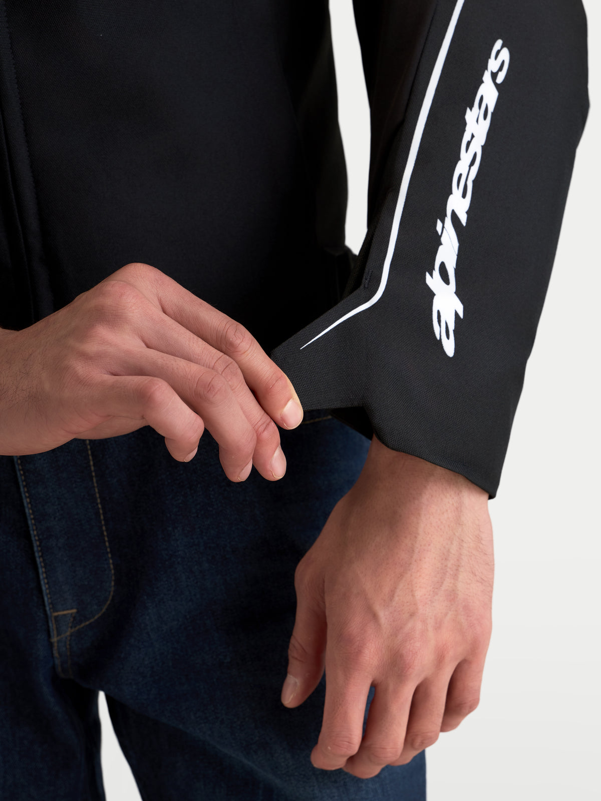 Alpinestars Zaca V2 Waterproof Jacket, close-up of the ergonomic wrist construction and secure cuff closure, Black and White, featuring the Alpinestars logo along the sleeve