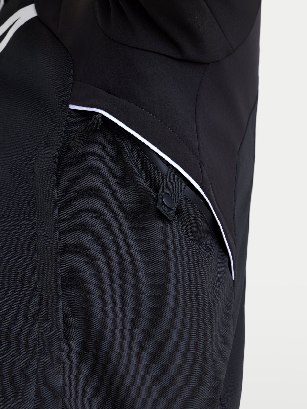 Alpinestars Zaca V2 Waterproof Jacket, close-up view of the black and white textile shell and zippered pocket construction for road motorcycle riding