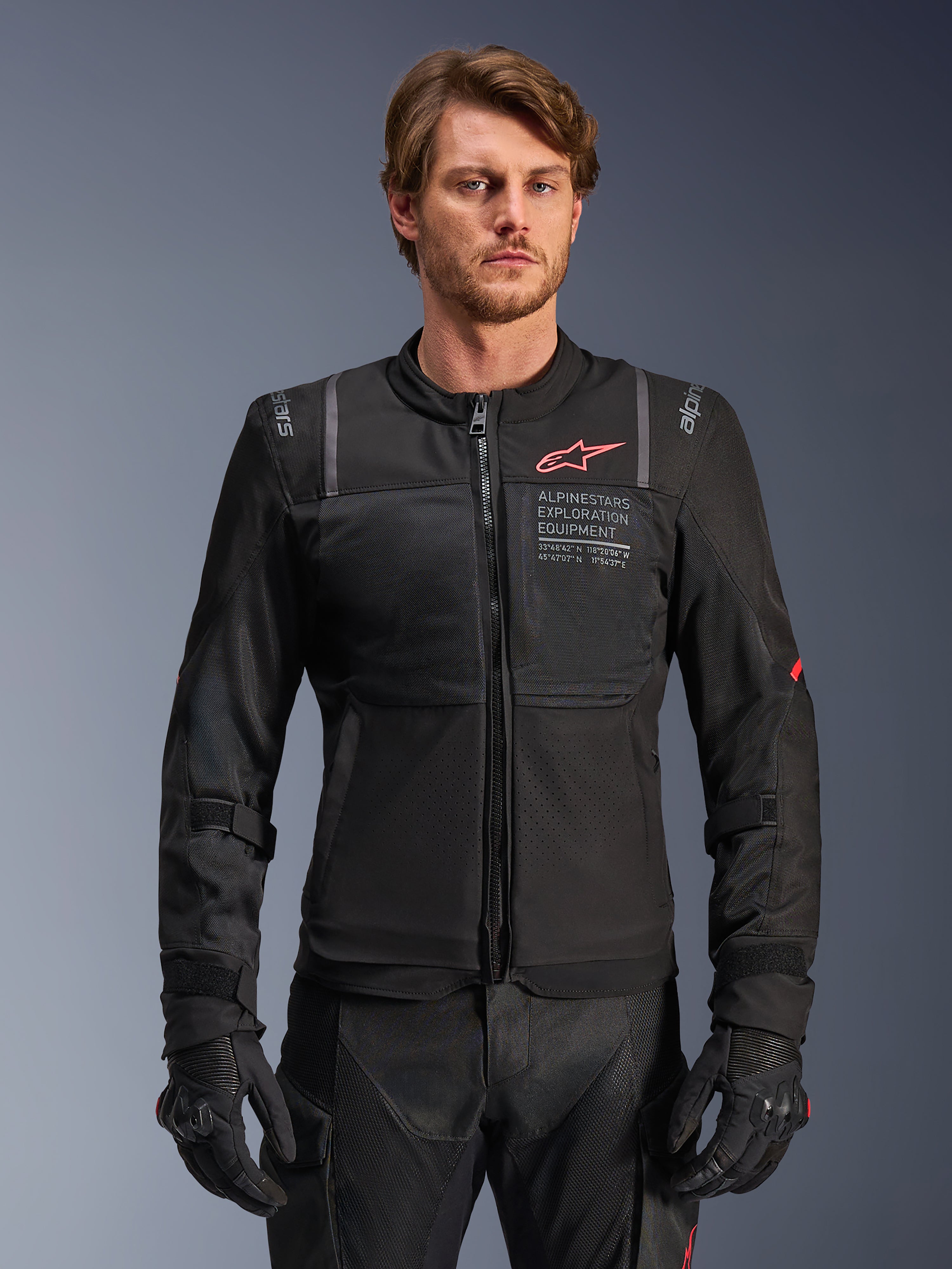Alpinestars ST-2 Air jas, zwarte heren-motorjas van textiel met meshpanelen en rode logo-branding, gedragen door model.