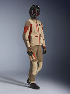Adventure rider wearing Maxdura Drystar®XF Laminated Armored Shell, Aluminum Walnut and Rust Brown jacket with matching walnut and tan pants, black carbon fiber helmet, and black motorcycle boots, technical touring gear for adventure motorcycling