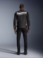 Veste Alpinestars T-Dyno WR, veste de moto en textile, noir, gris foncé et écru, vue de dos montrant une bande horizontale sur les épaules avec un petit logo étoile, portée par un mannequin avec pantalon noir et bottes, équipement de route d'inspiration vintage