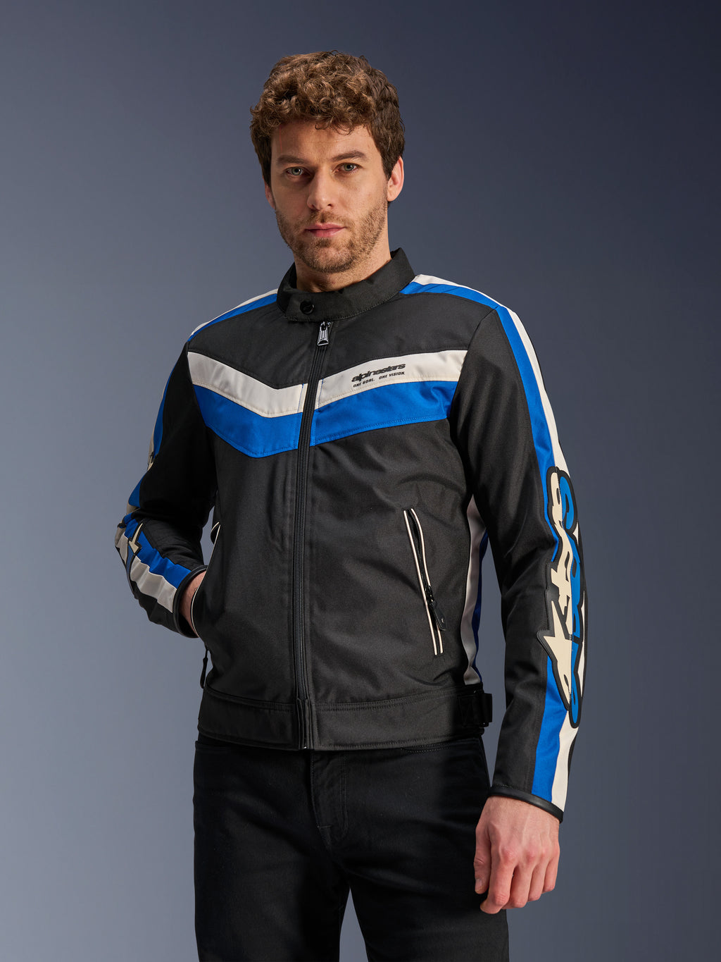 Veste Alpinestars T-Dyno WR en Noir Bleu Écru, veste de moto en textile avec rayures en chevron bleues et blanc cassé sur la poitrine et les manches, portée par un mannequin.