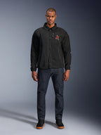 Alpinestars Revved WR Jas in het zwart, gedragen door een model met een donkerblauwe jeans en zwarte sneakers, vooraanzicht, met drukknopsluiting en een 3D geborduurd logo op de borst, urban contemporary motorkleding