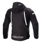 Blouson imperméable Alpinestars Zaca, blouson de moto, noir et blanc, vue arrière montrant la capuche amovible avec logo étoile blanc, bandes blanches verticales dans le dos, marquage Alpinestars sur l'ourlet inférieur et panneaux extensibles côtelés pour la mobilité.