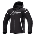 Veste imperméable Alpinestars Zaca, veste de moto noire avec capuche amovible, grand logo Alpinestars blanc sur la poitrine, bandes blanches sur le haut des bras et accents latéraux verticaux, fermeture éclair frontale, rembourrage renforcé aux épaules, sangles de réglage à la taille et aux bras, construction en textile softshell