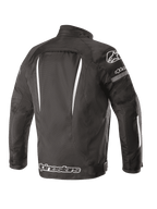 Alpinestars Gunner V2 Waterproof Jas, achteraanzicht, zwart en wit, textielconstructie met verticale witte accenten, groot Alpinestars-logo op de onderrug en A-star-logo op de schouder, urban motorkleding