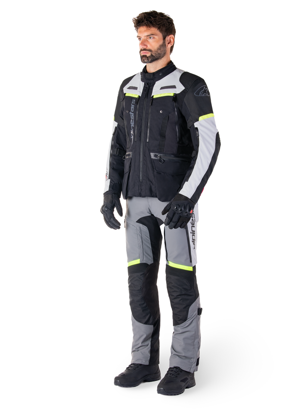 Alpinestars Bogotá Pro Drystar® Jacket, adventure touring motorcycle jacket, Black Ice Gray Yellow Fluo, worn by model with matching pants and black gloves, featuring waterproof textile construction with ventilation panels and fluorescent accents.
